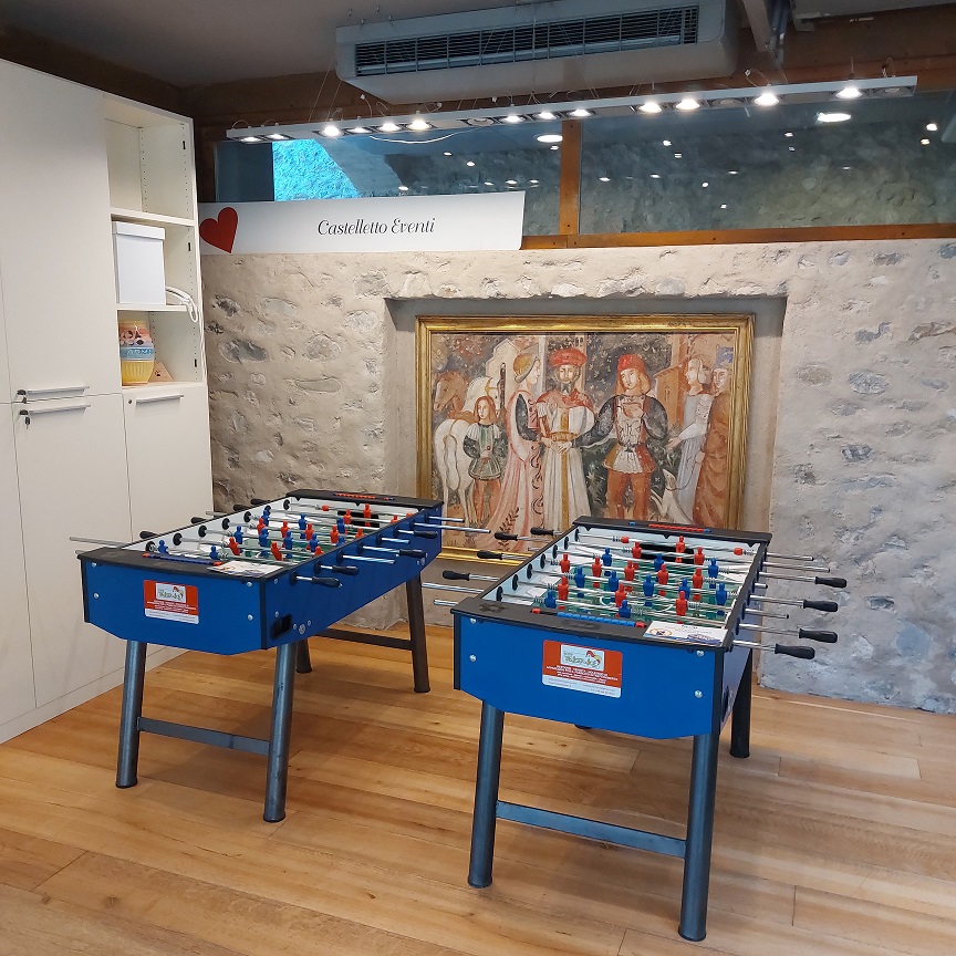 Due biliardini blu di New Treviservice su parquet davanti a muro in pietra e dipinto, insegna Castelletto Eventi